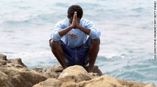 A migrant prays next to the sea in the city of Ventimiglia, Italy.