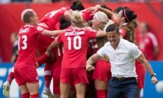 Canada coach John Herdman, right, celebrates as Josee Belanger, back, is mobbed by her team-mates after scoring against Switzerland in Vancouver.