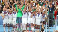 RIO DE JANEIRO, BRAZIL - JULY 13: Philipp Lahm of Germany lifts the World Cup trophy with teammates after defeating Argentina 1-0 in extra time as FIFA President Joseph S. Blatter and German Chancellor Angela Merkel look on during the 2014 FIFA World Cup Brazil Final match between Germany and Argentina at Maracana on July 13, 2014 in Rio de Janeiro, Brazil. (Photo by Martin Rose/Getty Images)