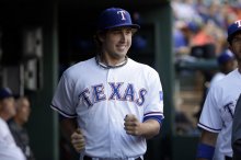 Texas Rangers' Derek Holland does a dance move in the dugout before a baseball game against the Houston Astros, Tuesday, Sept. 23, 2014, in Arlington, Texas. (AP Photo/Tony Gutierrez)